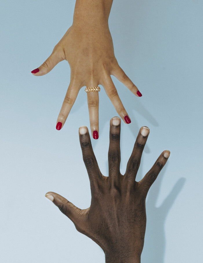 Bild på två händer, varav den ena bär en ring från Cartier.